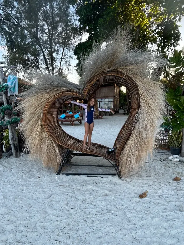 Olivia at the heart-seat on the beach — a Koh Lipe afternoon, kid-style